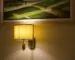 Warm wall lamp illuminating artwork and a painted wall