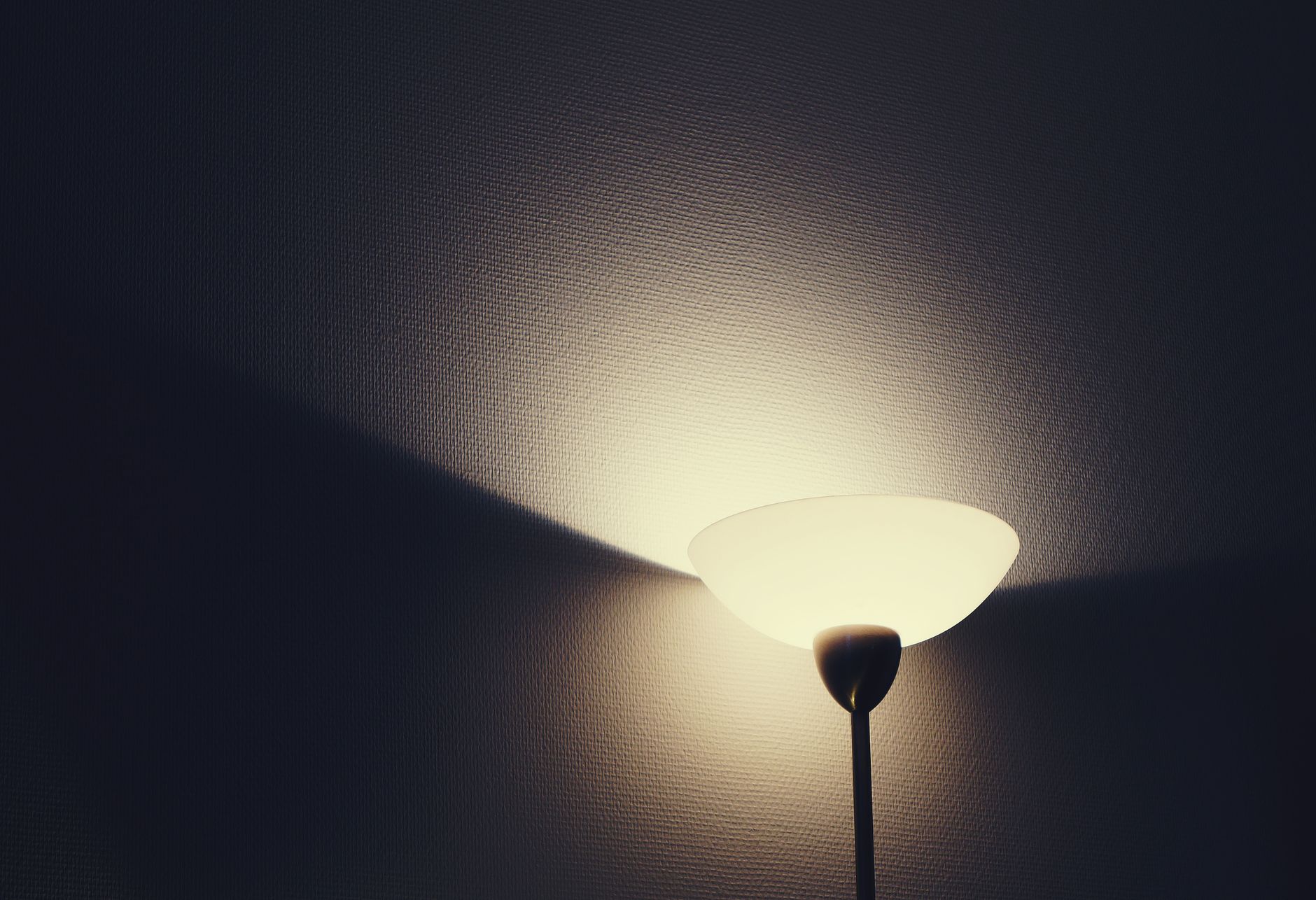 Floor uplighter casting a broad beam of warm light onto a wall